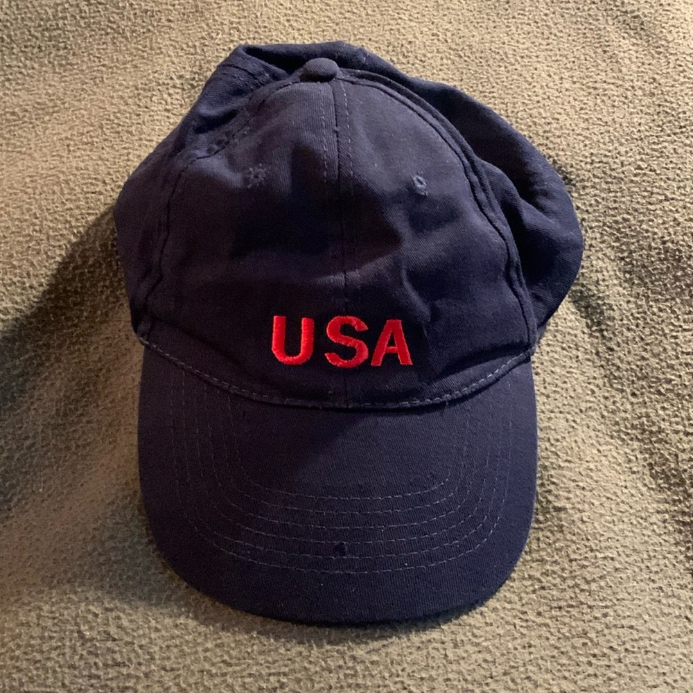Navy hat w/ red embroidered USA.  Hook & loop strap in back. One size fits all